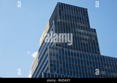 A stack or layers of dark architectural blocks set against a blue sky ...