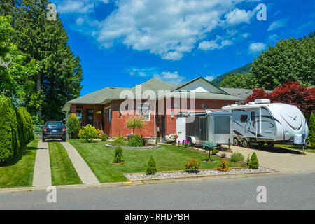 Family house with traced driveway over front yard and parked RV in front Stock Photo