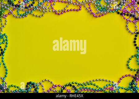 Yellow Mardi Gras background bordered with colored bead necklaces with room for text. Stock Photo