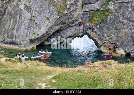 Rock climbing, tombstoning, canoeing, and orienteering at Lulworth Cove, Dorset, UK. Part of the Jurassic coast. Stock Photo