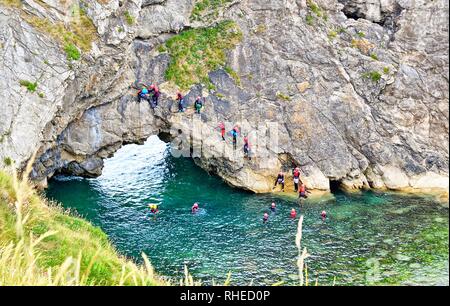 Rock climbing, tombstoning, swimming, and orienteering at Lulworth Cove, Dorset, UK. Part of the Jurassic coast. Stock Photo
