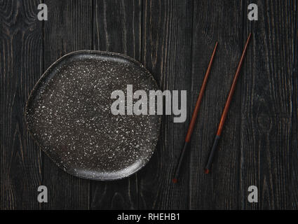 Plate and Chopsticks on the black table top Stock Photo