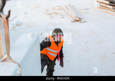 Worker fitter in a protective helmet and reflective vest on the working meast Stock Photo