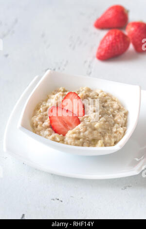 Bowl of oats with fresh strawberries on white background Stock Photo