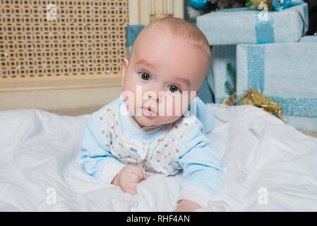 The baby lies on the blanket. The child in the New Year's decor. Picture Stock Photo