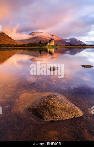 Kilchurn Castle captured at sunrise on a misty morning in the autumn. Stock Photo