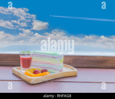 Abstract soft focus cocoa, coffee, rainbow crepe, lemon, grape, on the wooden tray with the beautiful blue sky and cloud. Stock Photo