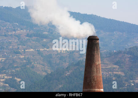 White smoke coming out of industrial chimney with smokey sky background. Air pollution, greenhouse effect and global warming problem concept. Stock Photo