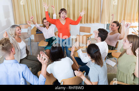 Portrait of delighted girl student with her groupmates and female teacher in university auditorium Stock Photo