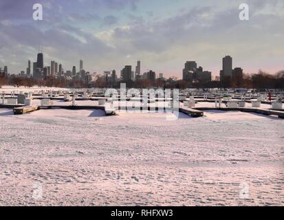Vacated Boat Harbor for Winter and Frozen Lake Michigan Covered in Snow During the Polar Vortex and Skyline View of Downtown Chicago. Stock Photo