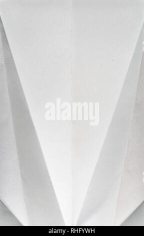Folded white colour paper. Pastel tones. Hard natural light. Folds and wrinkles on paper. Geometric shapes and figures on the paper. Stock Photo