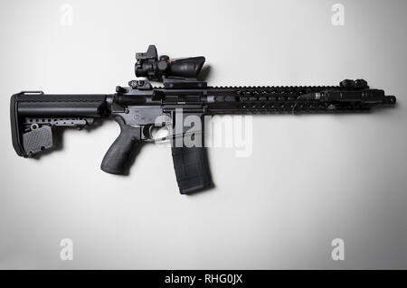 Black AR-15 pattern semi-automatic rifle on white background with rifle scope and flashlight Stock Photo
