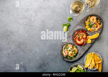 CEVICHE. Three colorful shrimps ceviche with mango, avocado and tomatoes. Latin American Mexican Peruvian Ecuadorian food. Served with white wine and Stock Photo