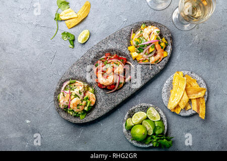 CEVICHE. Three colorful shrimps ceviche with mango, avocado and tomatoes. Latin American Mexican Peruvian Ecuadorian food. Served with white wine and Stock Photo