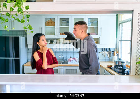 Lovely couple posing - young woman thinking what he's doing? Stock Photo