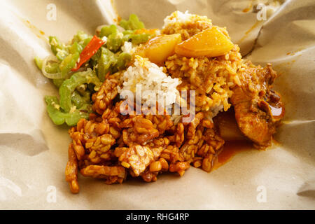 Typical Malaysian daily lunch called Nasi Campur or Nasi Bungkus which is loosely translated as rice mixed with vegetable, tempe, chicken or fish. Stock Photo