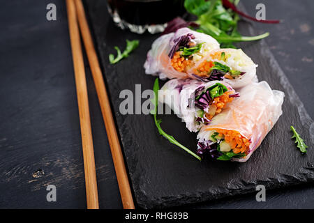 Vegetarian vietnamese spring rolls with spicy sauce, carrot, cucumber, red cabbage and rice noodle. Vegan food. Tasty meal.  Copy space Stock Photo