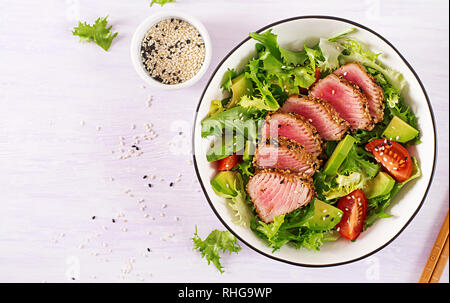 Tuna salad. Japanese traditional salad with pieces of medium-rare grilled Ahi tuna and sesame with fresh vegetable on a bowl. Authentic Japanese food. Stock Photo