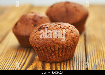 Chocolate muffin with dark background test on an old wooden table. Stock Photo