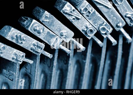 Detail of the individual hammers with engraved text and typescript inside vintage mechanical typewriter. Stock Photo