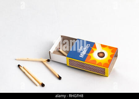 close up of a box of matches with some used matches next to it Stock Photo