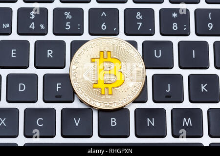 Golden cruptocurrency bitcoin, yyellow bitcoin on computer key board. Stock Photo