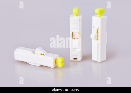 white lancets on a white background. Blood sampling for analysis, piercing a finger with a lancet. Blood tests, laboratory tests. Lancet tool Stock Photo