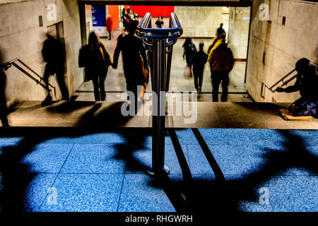 beggar sitting on stairs in metro station in Athens Stock Photo