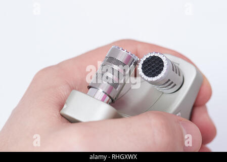 Close-up of hand holding audio recorder isolated on white background Stock Photo