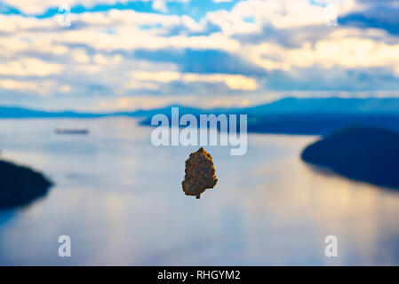 Cannabis bud floating in front of a beautiful ocean landscape with cloudscape, taken in Vancouver Island, Canada Stock Photo