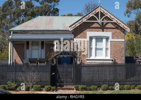 A Federation era brick and steel roofed home with a bull nose front veranda and fret work over the hip roof end in Millthorpe, New South Wales, Aust. Stock Photo