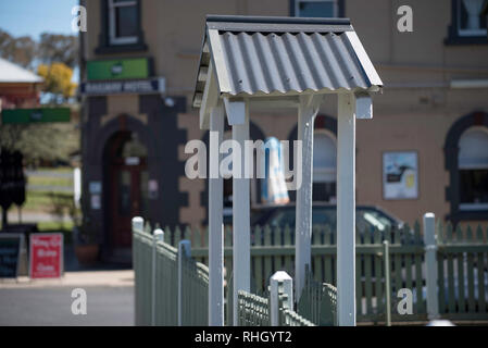 A small timber and tin roofed, arched gate sits neatly between a line of painted picket fence surrounding a home in Millthorpe, New South Wales, Aust. Stock Photo