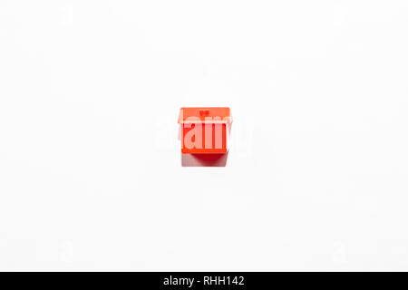 View from the top of the plastic miniature house in red as a part of the monopoly game on a white isolated background Stock Photo