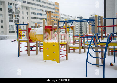 Modern beautiful Playground in the new area on the background of multi-storey buildings in winter. Stock Photo