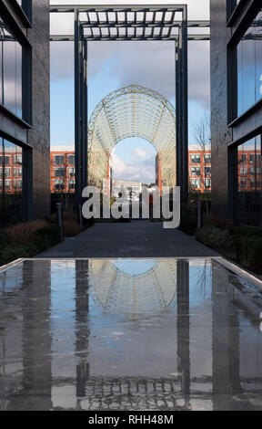 Historic airship hangar, built in 1912 on original Farnborough Airfield site, now Farnborough Business Park. Structure is reflected in pool of water. Stock Photo