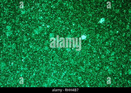 Green Sponge Foam Texture Macro Background. Abstract background of a thin layer of foam rubber. Translucent material. Fibers Stock Photo