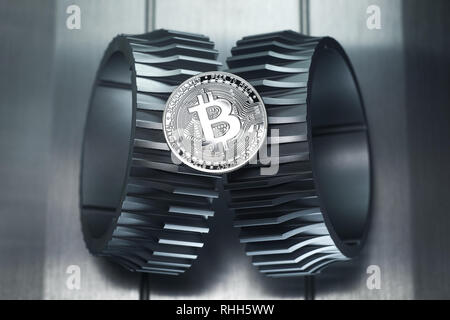 Silver bitcoin lies on the metal gearwheel. Digital Crypto currency revolution. Stock Photo