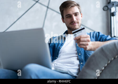 technology, shopping, banking, home and lifestyle concept - close up of man with laptop computer and credit card at home. Stock Photo