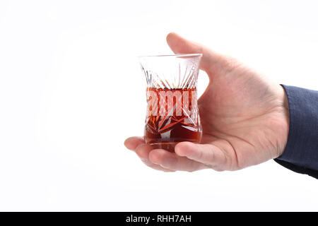 Glass Turkish armud with tea in male hand on a white background Stock Photo