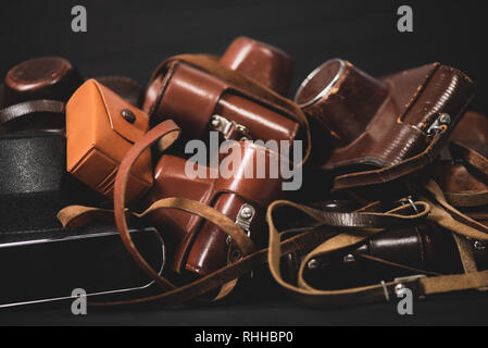 Heap of 35mm vintage cameras in leather covers. Collecting Stock Photo