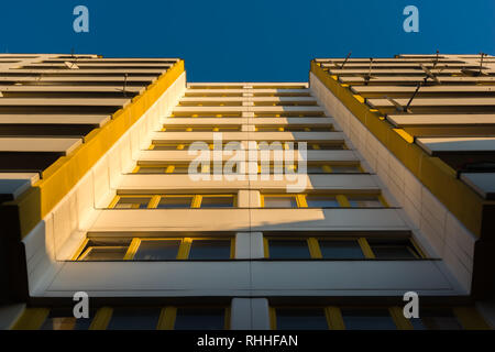 An apartment building with yellow windows in the morning light in Berlin Stock Photo