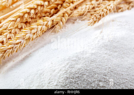 heap of wheat flour with ears of wheat Stock Photo