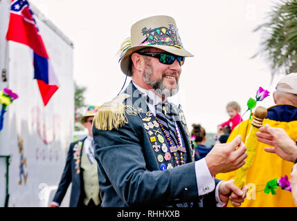Dauphin Island, Alabama, USA. 2nd Feb, 2019. A member of the Ole Biloxi Marching Club gives a flower to a spectator at the Krewe de la Dauphine Mardi Gras parade, Feb. 2, 2019, in Dauphin Island, Alabama. The Dauphin Island parade kicks off the official Mardi Gras parade season in Mobile, Alabama. (Photo by Carmen K. Sisson/Cloudybright) Credit: Carmen K. Sisson/Cloudybright/Alamy Live News Stock Photo