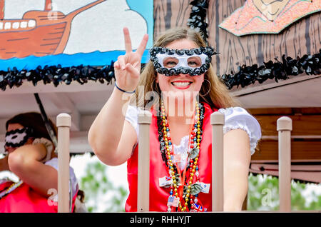 Dauphin Island, Alabama, USA. 2nd Feb, 2019. A woman wearing a Mardi Gras mask flashes a peace sign as she rides a Mardi Gras float in the Krewe de la Dauphine Mardi Gras parade, Feb. 2, 2019, in Dauphin Island, Alabama. The Dauphin Island parade kicks off the official Mardi Gras parade season in Mobile, Alabama. Mobile’s first official Mardi Gras celebration was recorded in 1703.   (Photo by Carmen K. Sisson/Cloudybright) Credit: Carmen K. Sisson/Cloudybright/Alamy Live News Stock Photo