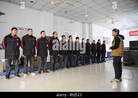 Xi'an, China's Shaanxi Province. 3rd Feb, 2019. Deliveryman Luo Feilong (3rd L) attends a meeting at a distribution center in Xi'an, capital of northwest China's Shaanxi Province, Feb. 3, 2019. Luo Feilong, a 31-year-old deliveryman from Shaanxi Province, has been delivering packages in a community of Xi'an for four years. Luo applied for being on duty during this year's Spring Festival holiday so that other deliverymen from outside the province can return to their hometowns for family gatherings. Credit: Zhang Bowen/Xinhua/Alamy Live News Stock Photo