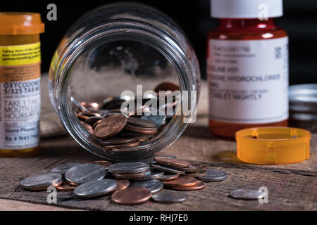 Glass mason jar with a few coins inside with prescription drugs Stock Photo