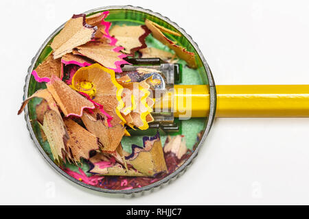 Pencil sharpener with color shavings on a white background. View from above Stock Photo