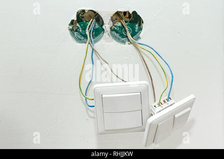 The switch hangs on the wires. Connect the wires during home renovation. Stock Photo