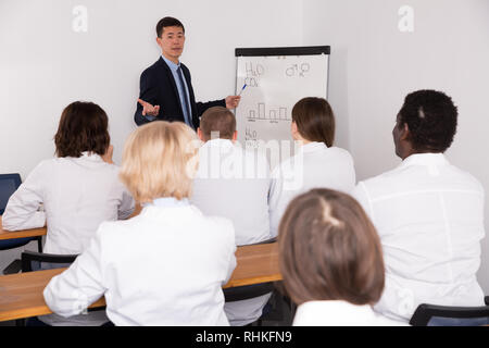 Confident Korean male giving lecture to colleagues at medical meeting Stock Photo