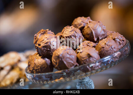 Sweet-stuff covered with chocolate syrup at bakery display Stock Photo